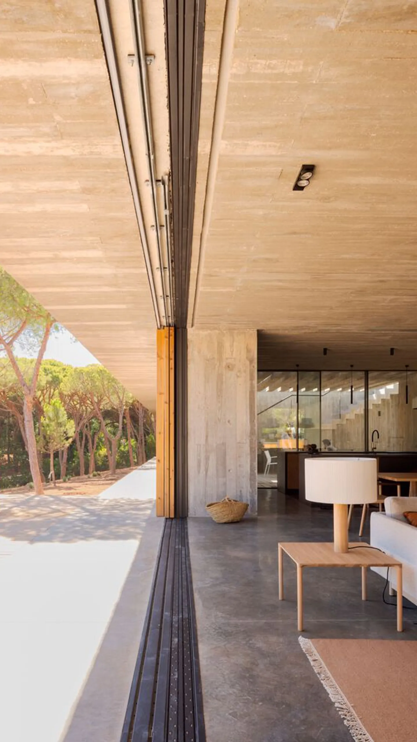 Sliding glass threshold joining interior and shaded terrace