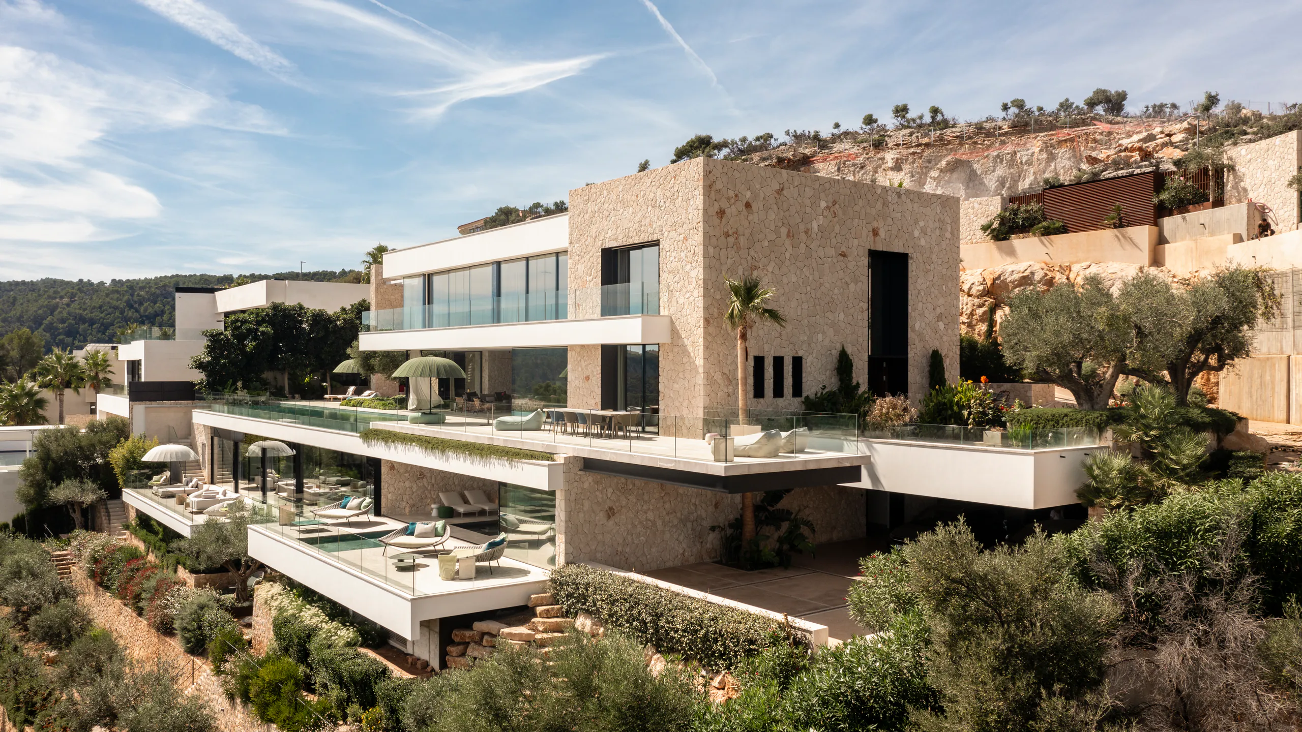 Panoramic hillside residence shaped by broad minimal glass