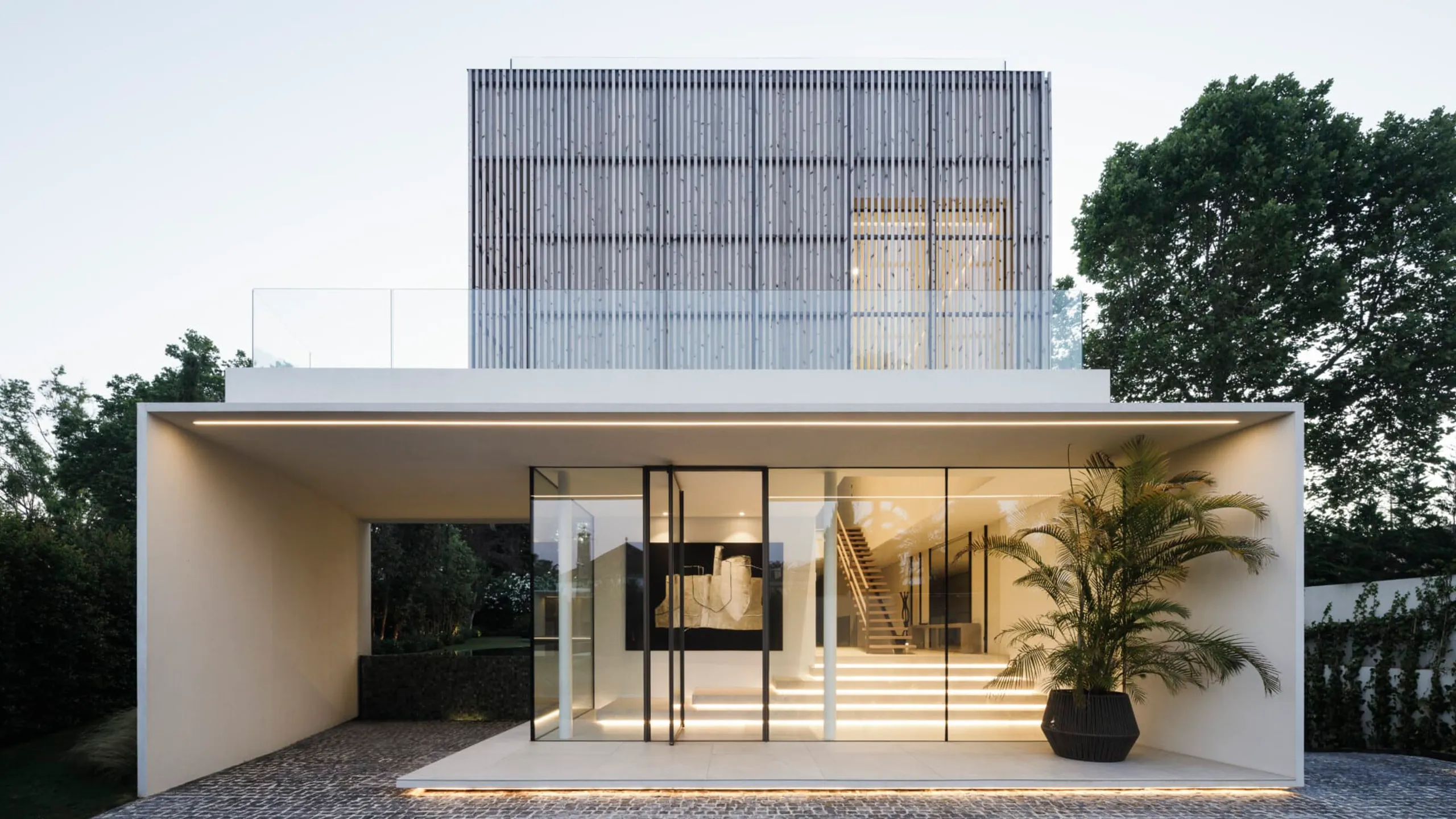 Minimal white residence presenting large protected openings