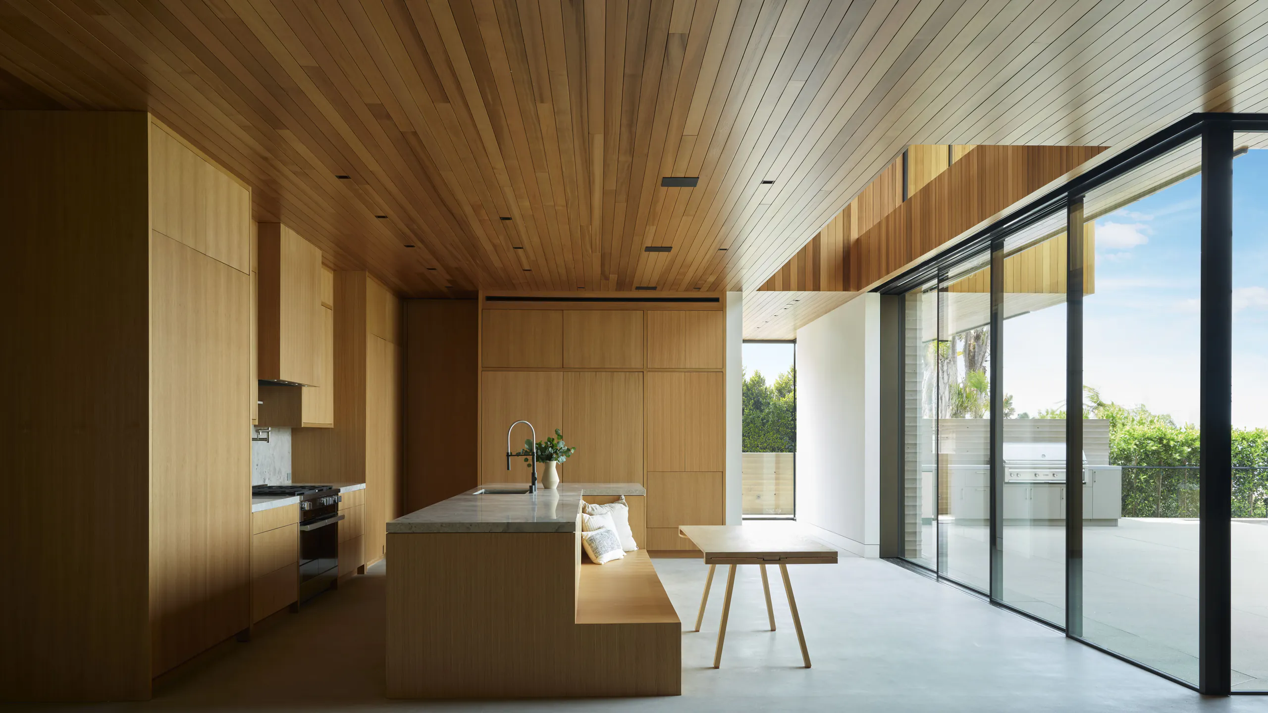 Tropical kitchen opening fully through minimal sliding doors